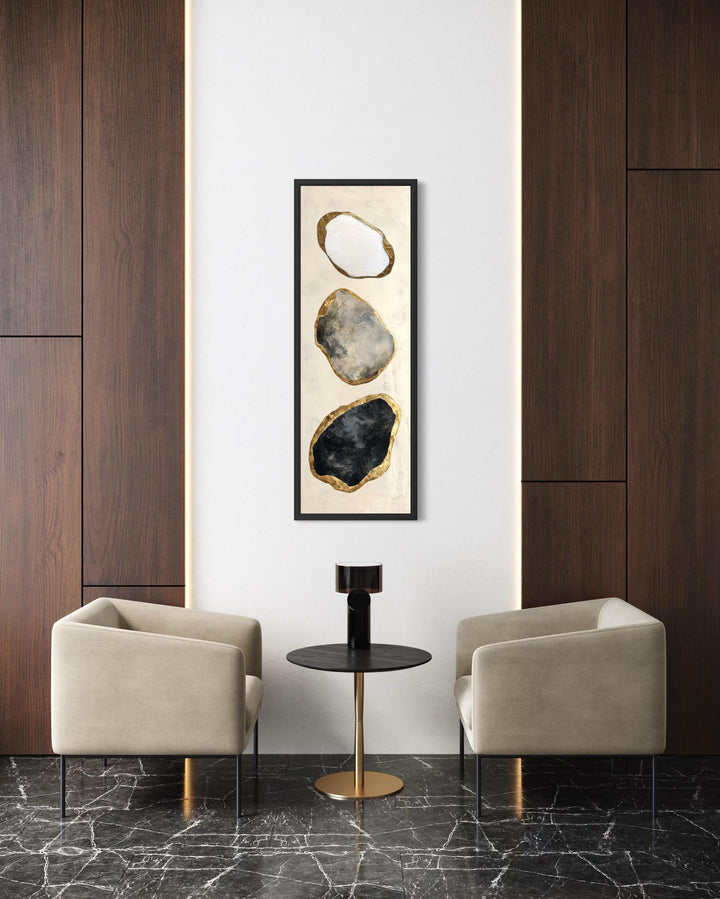 Vertical abstract wall art featuring three stacked rocks in white, grey, and black with gold edges.