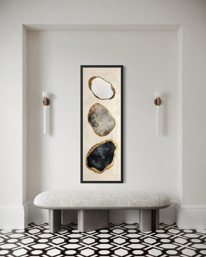 Vertical abstract wall art featuring three stacked rocks in white, grey, and black with gold edges.