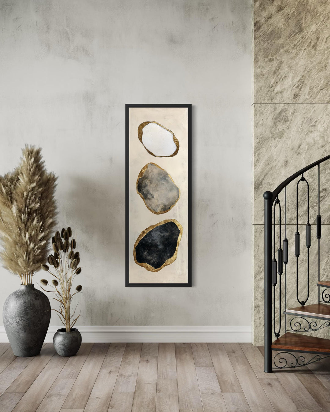Vertical abstract wall art featuring three stacked rock shapes in white, grey, and black with gold.