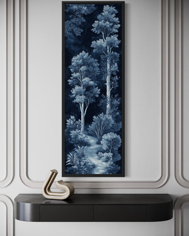 Vertical narrow wall art featuring a blue and navy night forest scene above a dark console table.