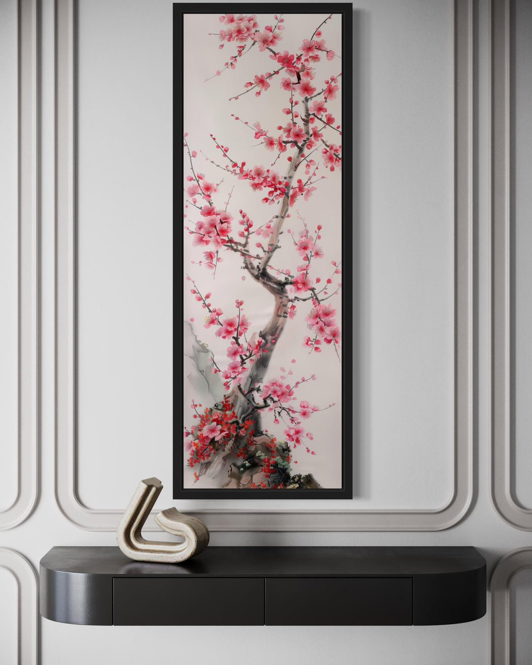 Vertical narrow wall art featuring a cherry blossom tree in a black frame above a dark console.