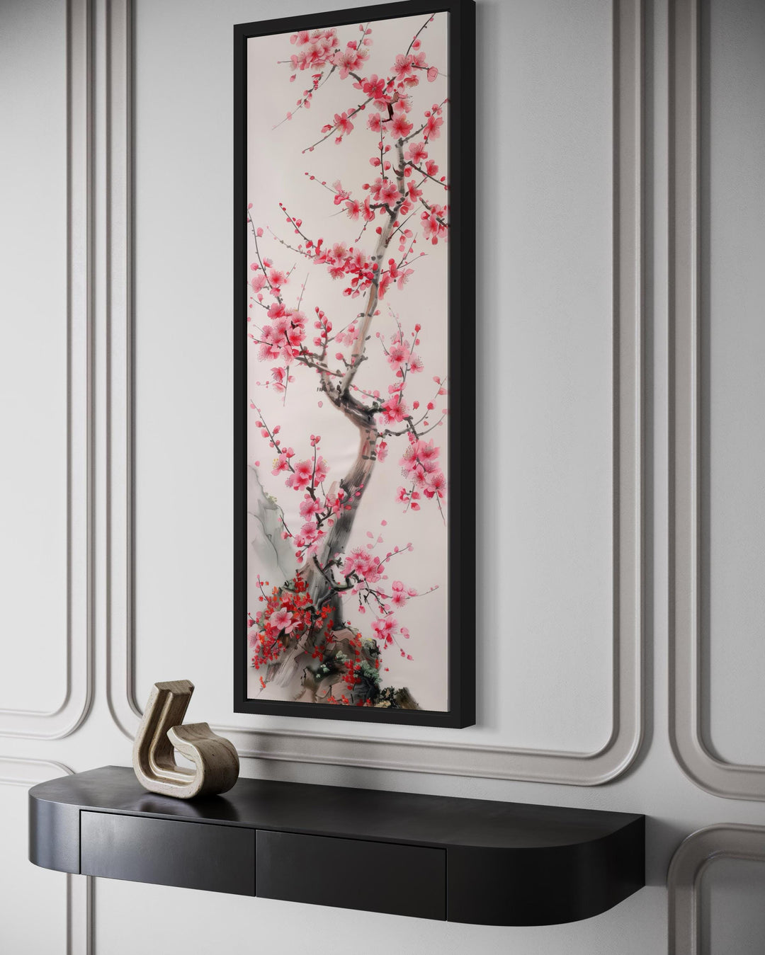 Vertical narrow wall art featuring a cherry blossom tree in a black frame above a console table.