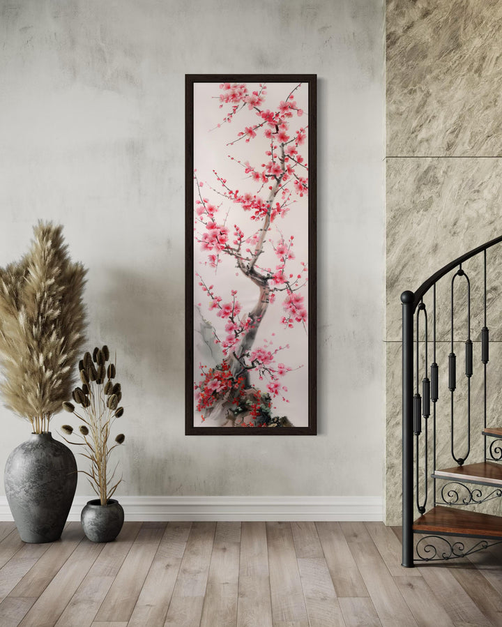Vertical narrow wall art featuring a cherry blossom tree in a dark frame on a neutral wall.