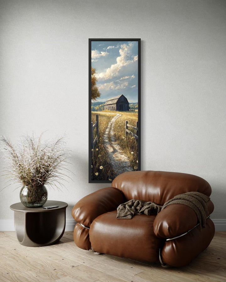 Vertical narrow canvas wall art of a farmhouse barn in a golden wheat field on a white wall.