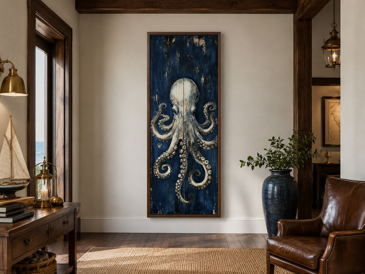 Vertical octopus wall art with metallic tentacles on a deep navy canvas in a coastal living room.