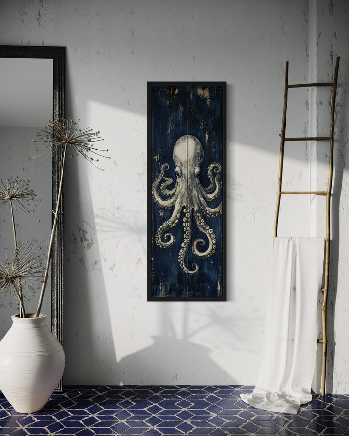 Vertical octopus canvas wall art with metallic tones on a navy background in a coastal room setting.