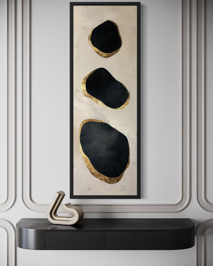 Vertical tall narrow wall art with three black and gold abstract rock shapes on a neutral background