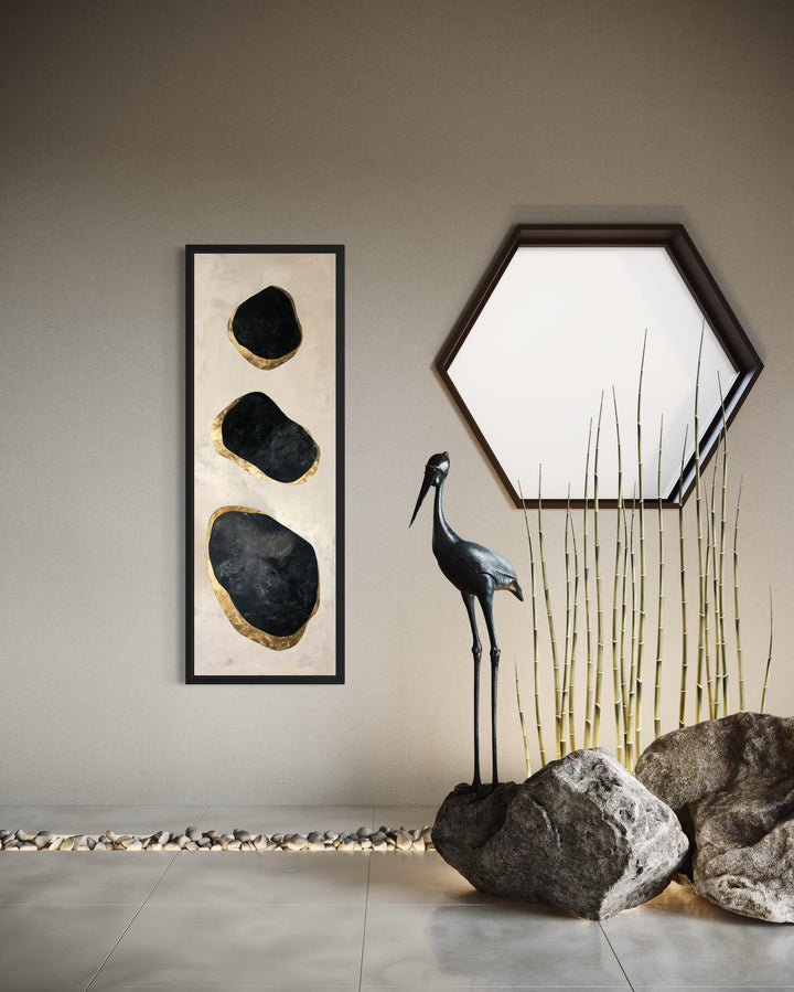 Vertical tall narrow wall art featuring three black and gold abstract rock shapes on a cream canvas.