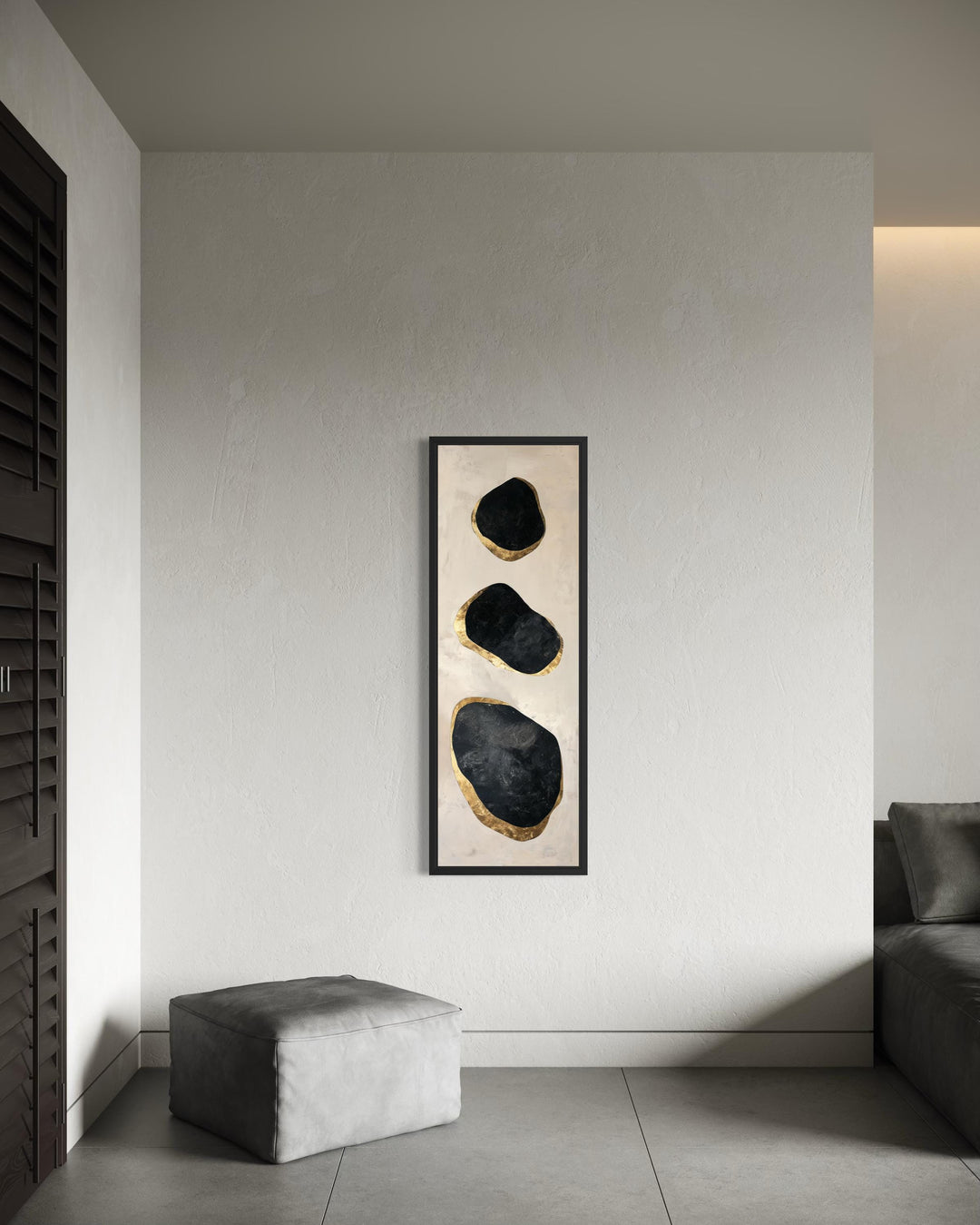 Vertical tall narrow wall art featuring three abstract black and gold rock shapes on a neutral wall.
