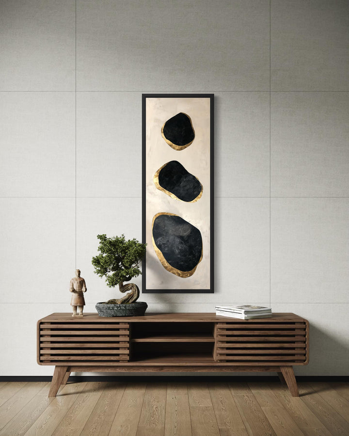 Vertical tall narrow wall art featuring three black and gold abstract rocks on a neutral background.