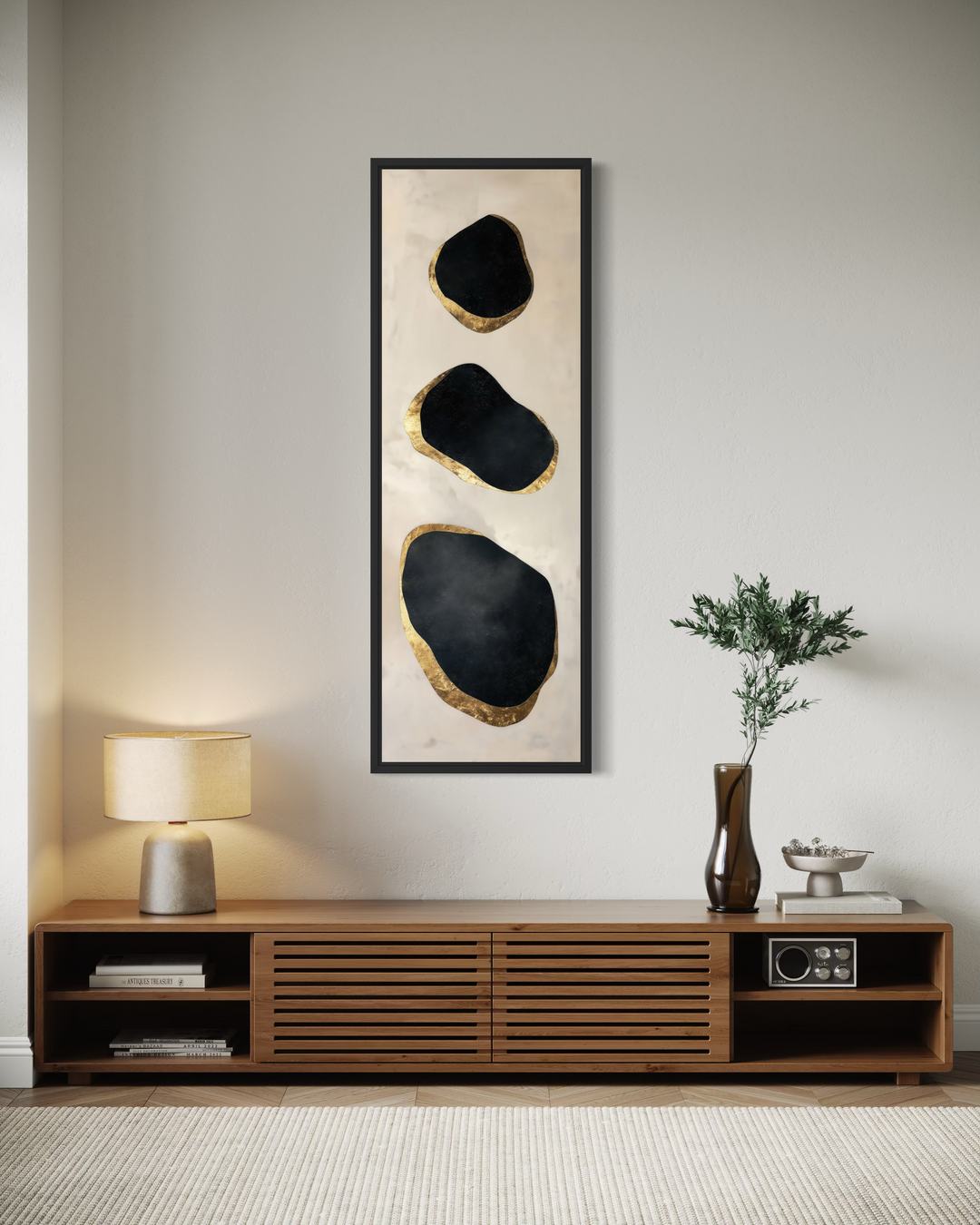 Vertical tall narrow wall art featuring three black and gold abstract rocks in a black frame.