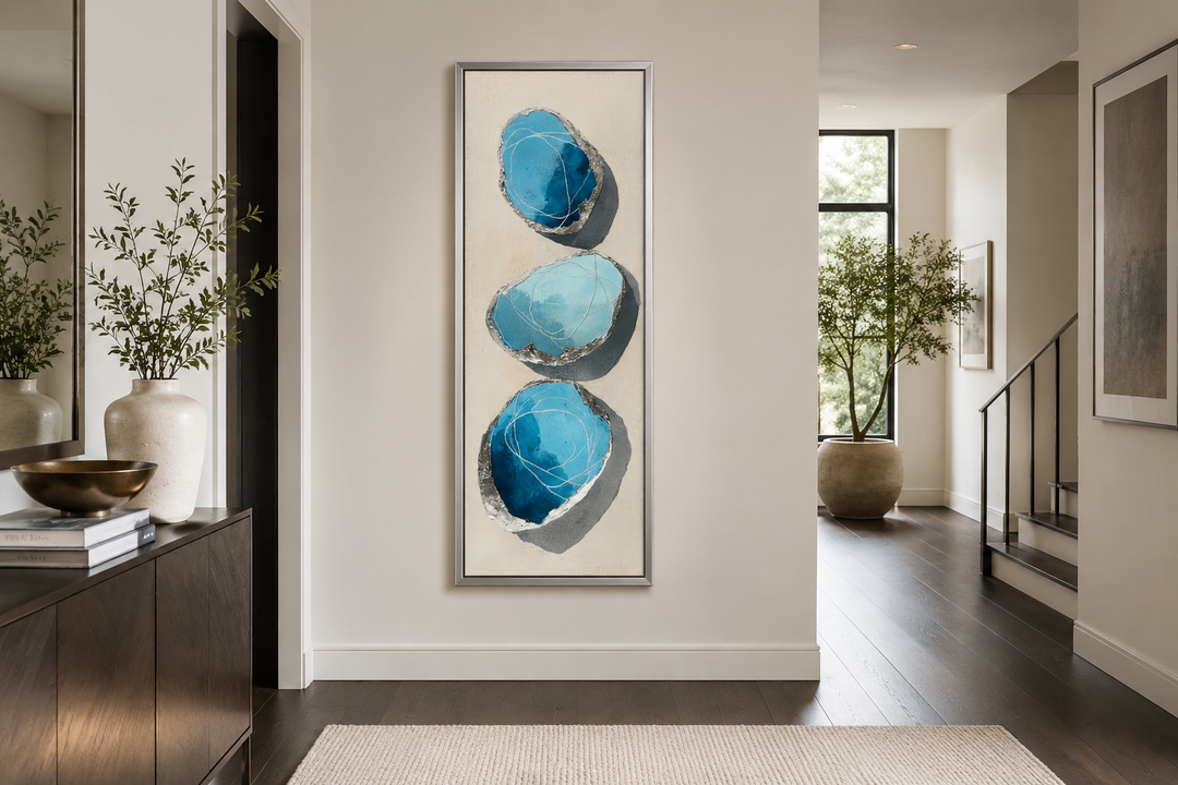 Vertical canvas print of three stacked abstract blue stones with silver outlines on a neutral wall.