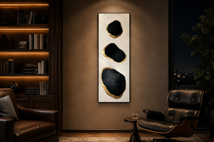 Vertical tall narrow wall art with three abstract black and gold rock shapes on a neutral canvas.