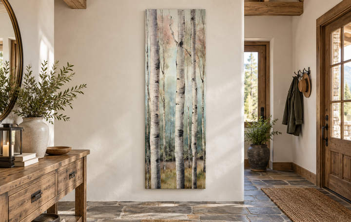 Long narrow vertical watercolor birch trees framed canvas wall art in a rustic entryway.
