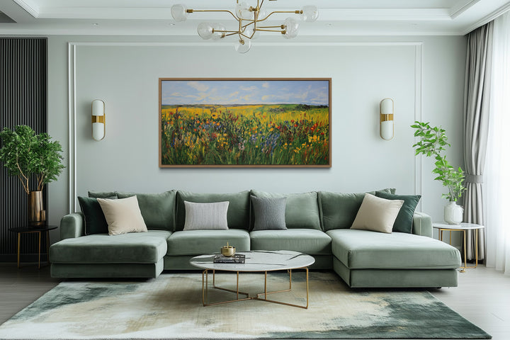 Vibrant impressionist green and yellow wildflower meadow framed canvas art above a green sofa.