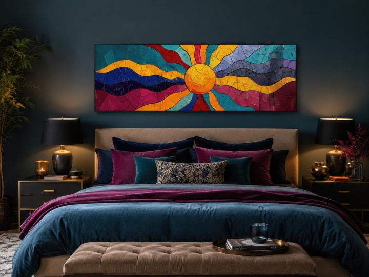 Vibrant multicolored sun long horizontal canvas wall art hanging above a bed in a dark teal room.