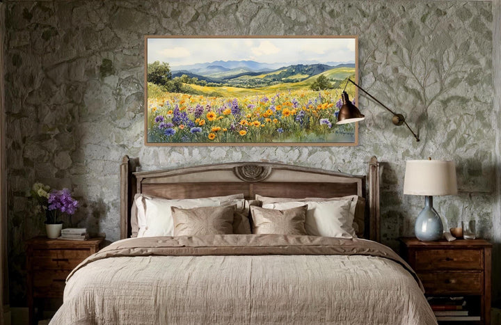 Vibrant yellow and purple wildflower field canvas wall art in a wood frame above a bed.
