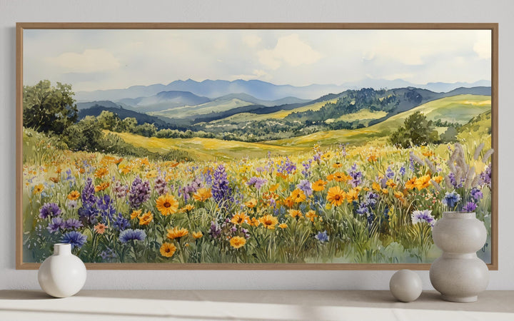 Panoramic watercolor painting of a yellow and purple wildflower field with distant blue mountains.