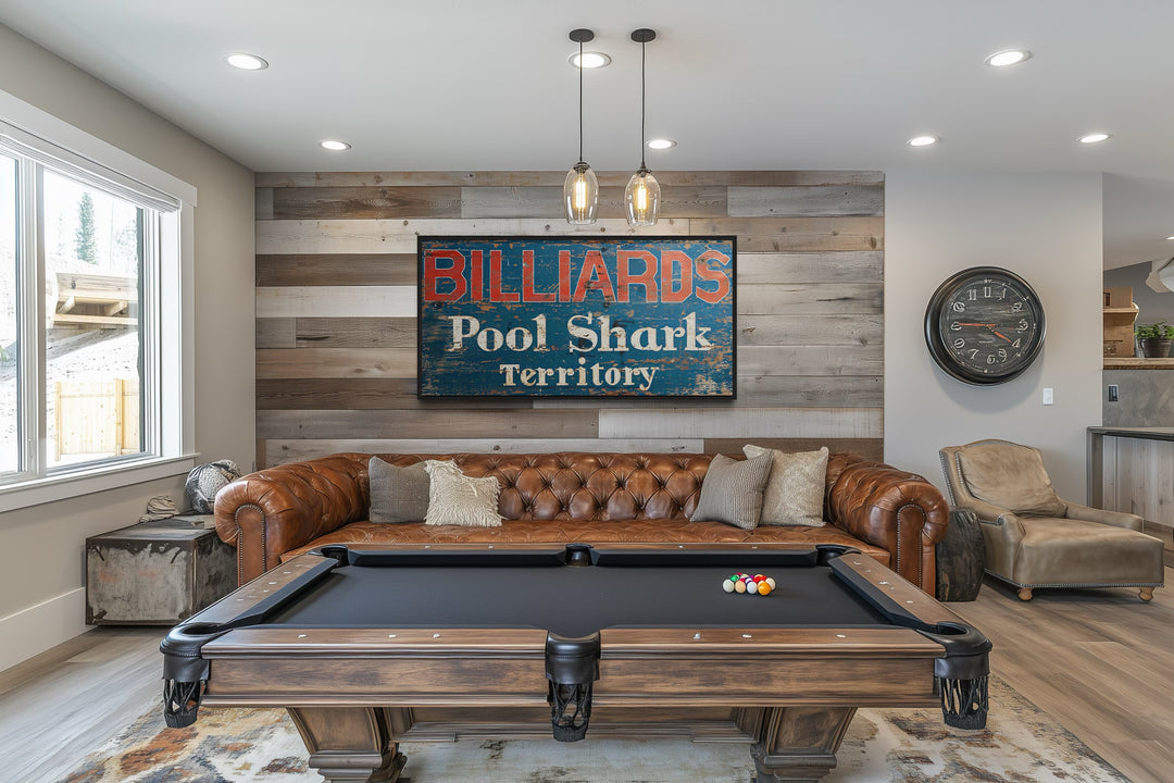 Vintage Billiards Pool Shark Territory sign on a wood-paneled wall above a brown leather sofa.