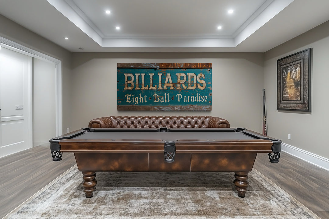Vintage Billiards Sign wall art above a pool table and leather sofa in a modern game room.