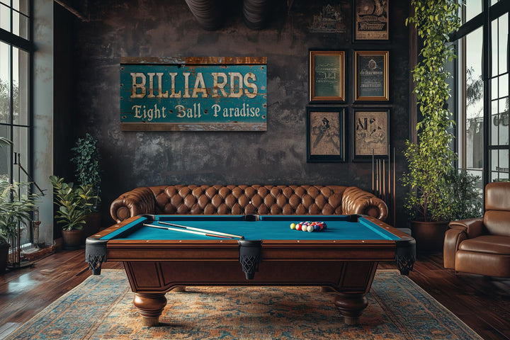 Vintage Billiards Eight Ball Paradise sign on a dark wall above a pool table in a game room.