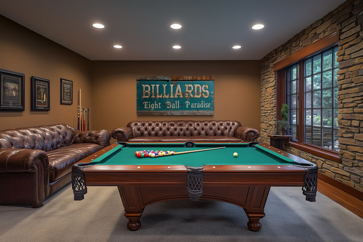 Vintage Billiards Eight Ball Paradise sign on a brown wall above a leather sofa in a game room.