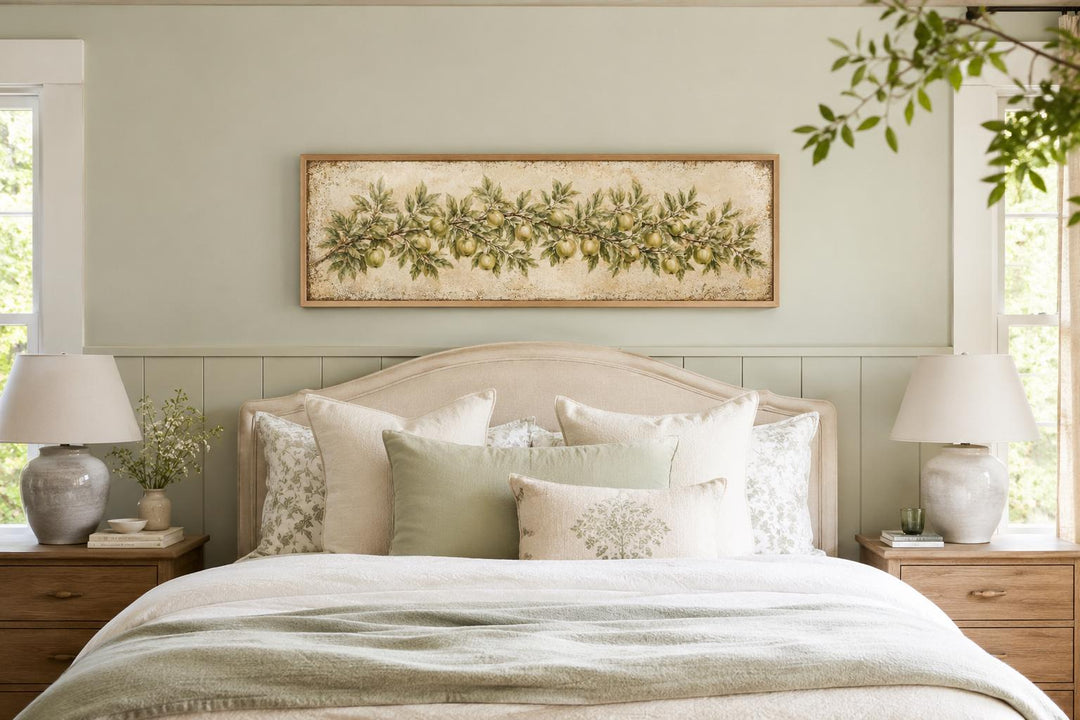 Long narrow vintage botanical canvas painting of a green apple branch above a bed.