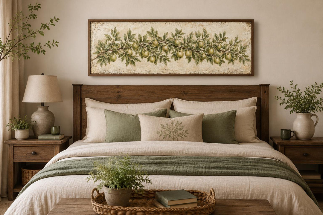Long narrow vintage botanical canvas painting of a green apple branch above a wooden bed frame.
