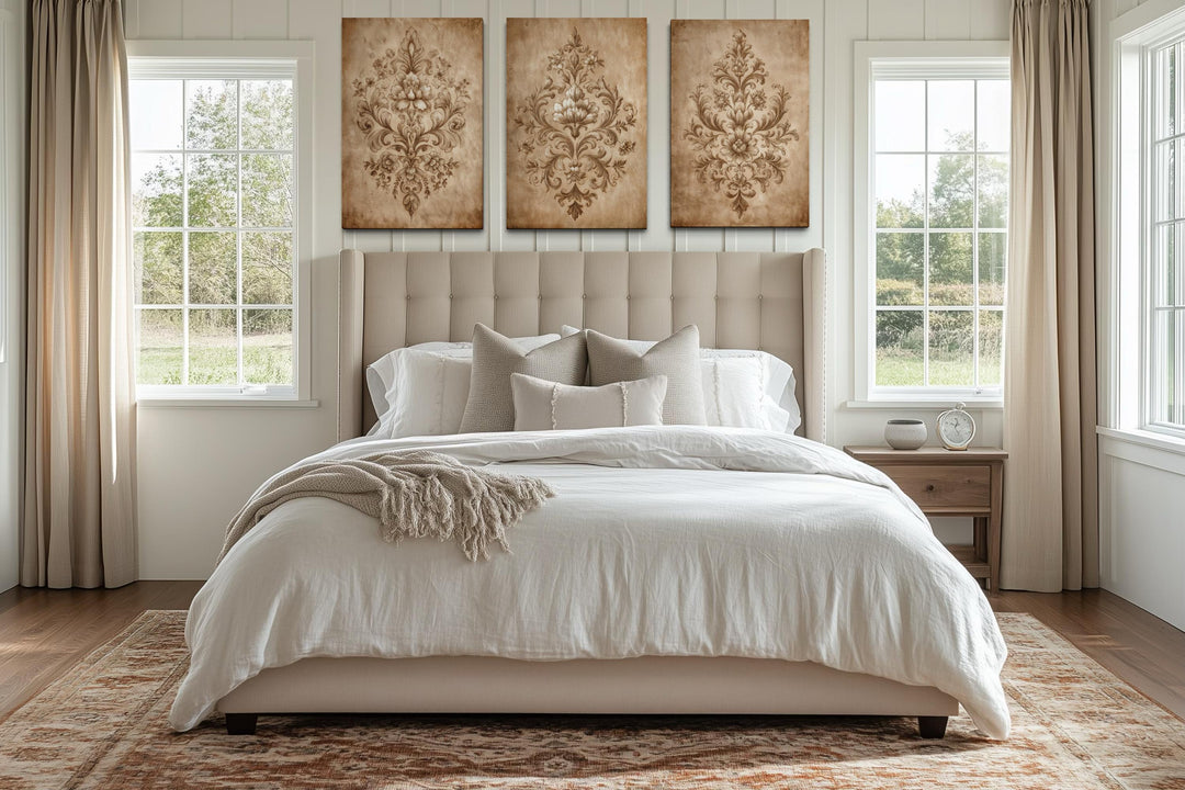 Set of three vintage damask canvas prints with neutral beige ornamental patterns above a bed.