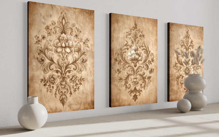 Three vertical canvas prints featuring intricate beige damask patterns on a vintage-style background.