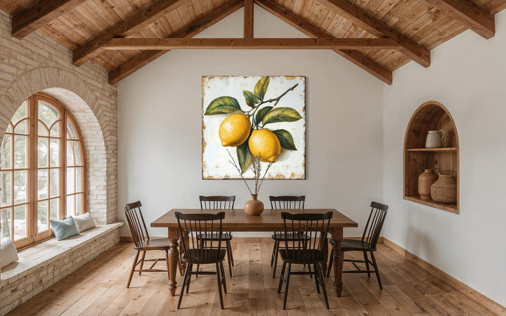 Rustic lemon botanical canvas print hanging in a farmhouse dining room with wooden beams.