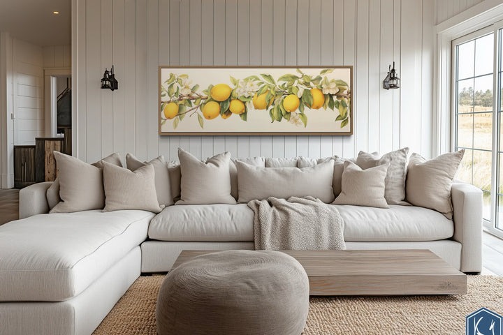 Vintage lemon tree panoramic framed canvas wall art hanging above a neutral sectional sofa.