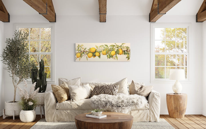 Vintage lemon tree panoramic framed canvas wall art hanging above a cream sofa in a rustic room.