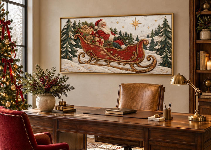 Vintage Santa Claus in a red sleigh framed canvas wall art hanging above a wooden desk.
