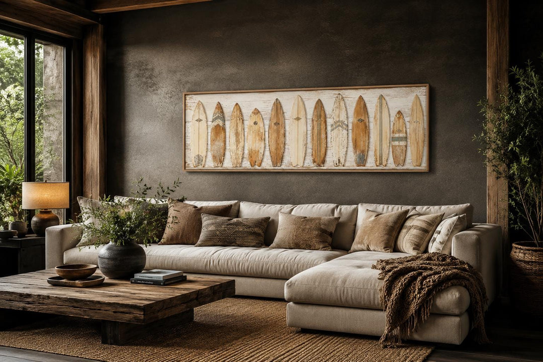 Vintage surfboard wall art in a horizontal frame above a beige sectional sofa in a coastal room.