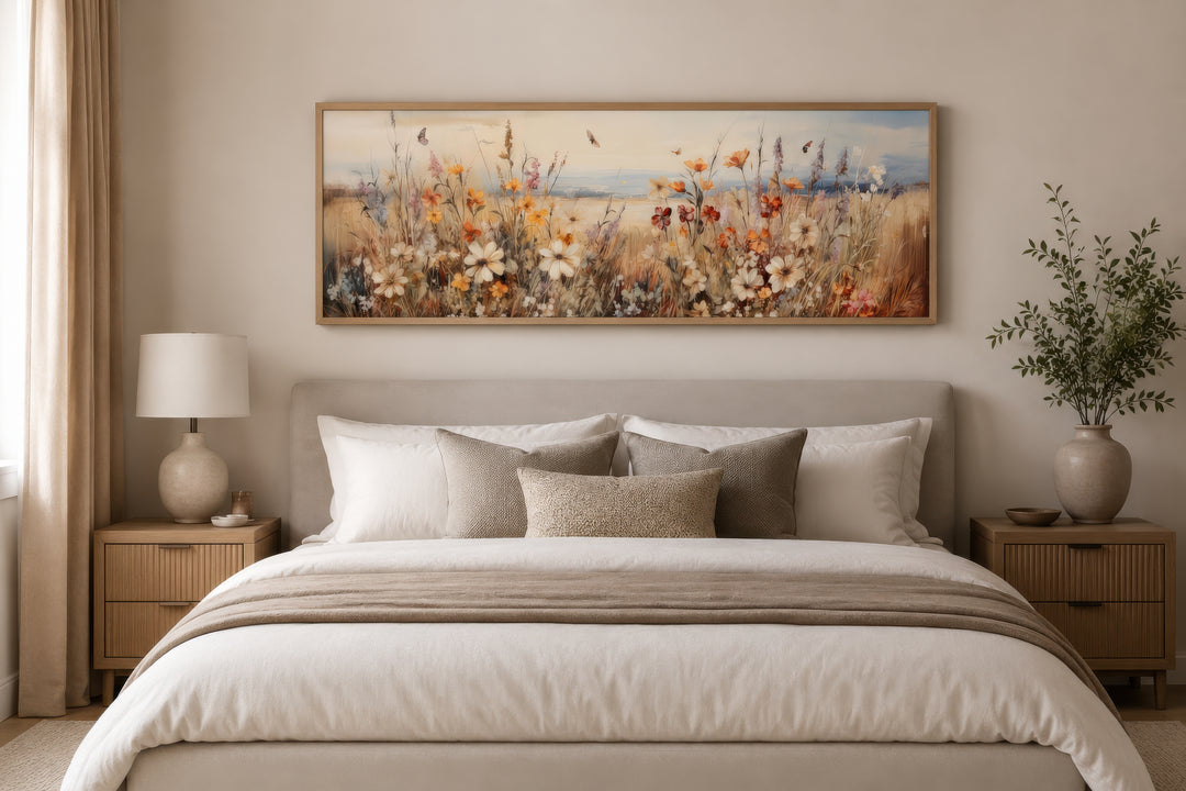 Vintage wildflowers field canvas wall art in a long horizontal frame hanging above a bed.