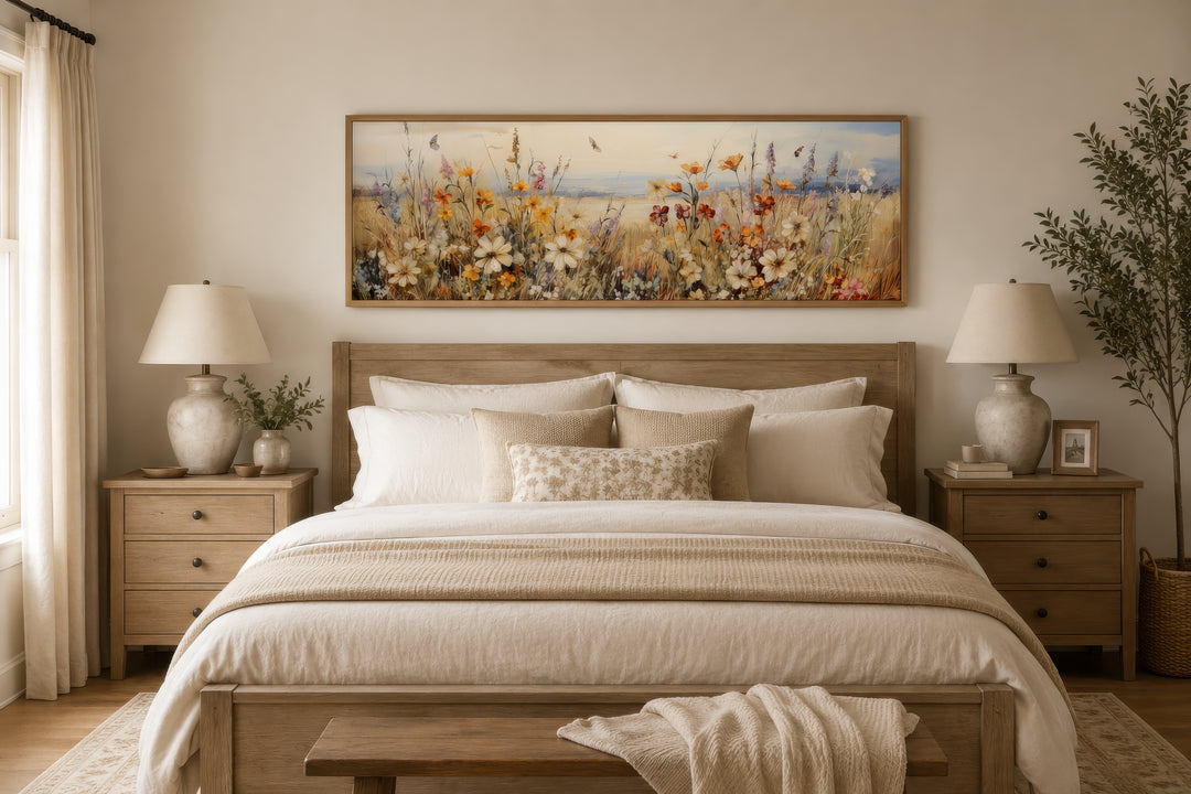 Vintage wildflowers field canvas wall art in a long horizontal frame hanging above a bed.