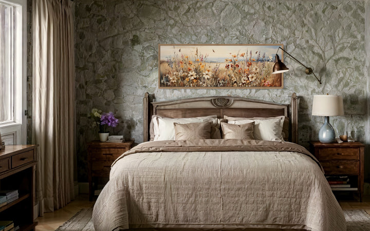 Vintage wildflowers field canvas wall art in a long horizontal frame displayed above a bed.