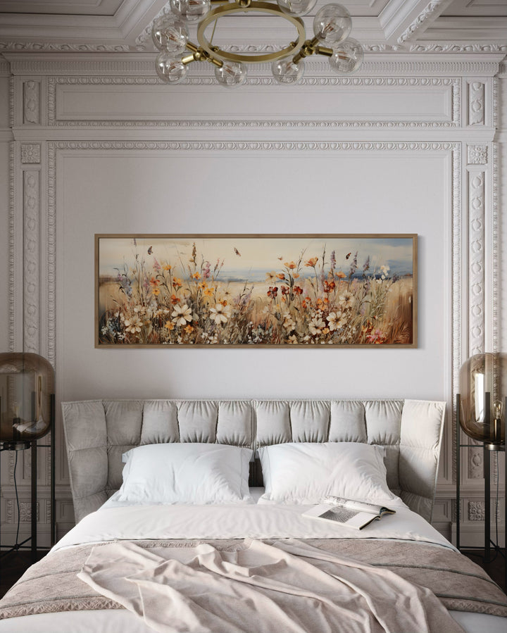Vintage wildflowers field canvas wall art in a long horizontal frame hanging above a bed.