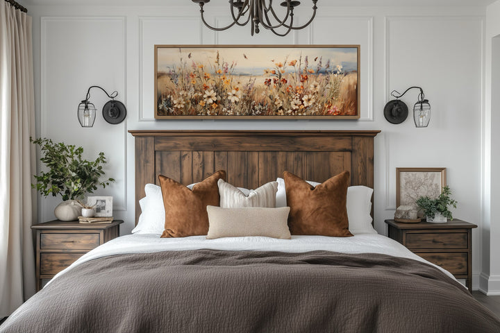 Horizontal canvas wall art featuring a vintage wildflower field in muted earth tones above a bed.