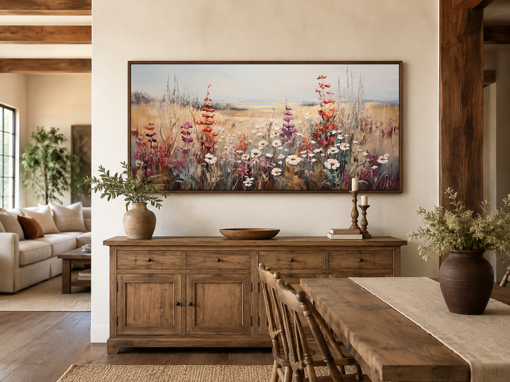 Vintage wildflowers field canvas wall art in a wooden frame above a rustic sideboard.
