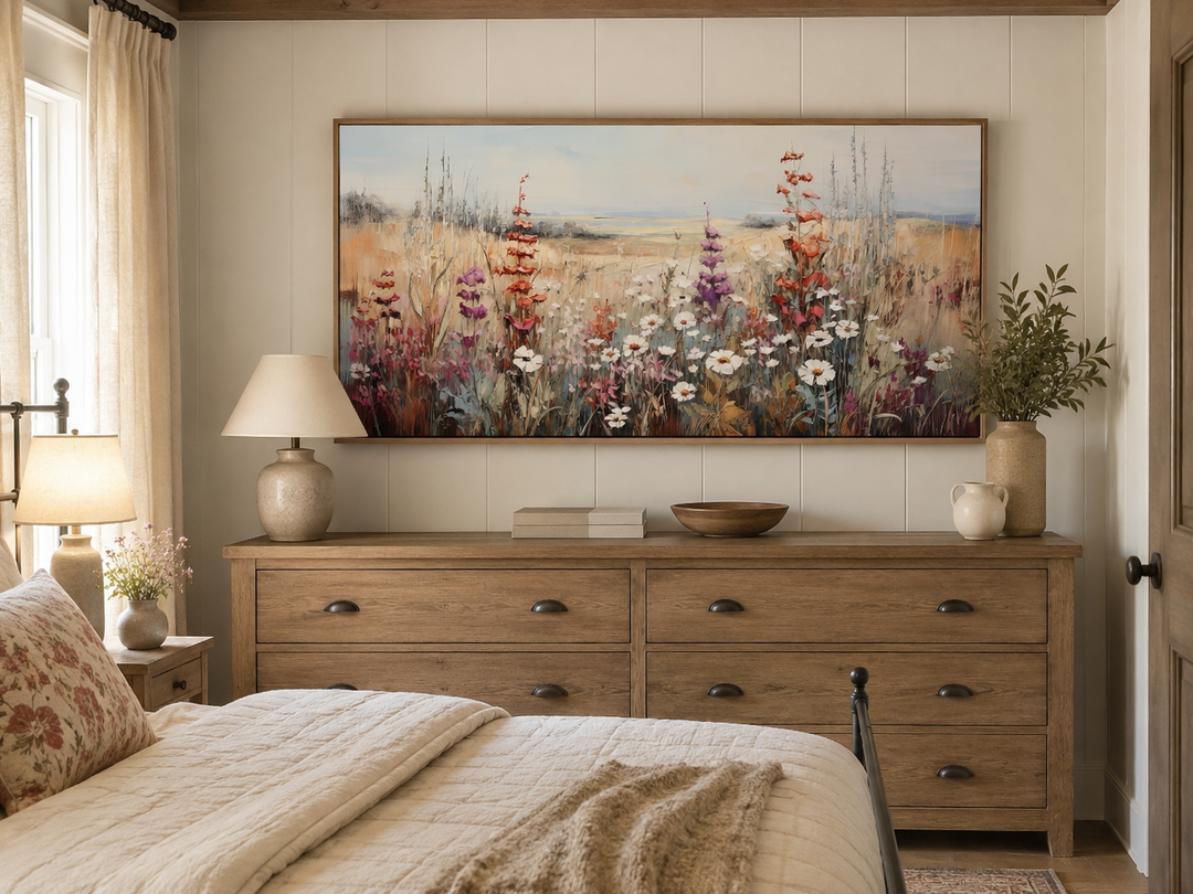 Vintage wildflowers field canvas wall art in a wooden frame above a rustic dresser in a bedroom.