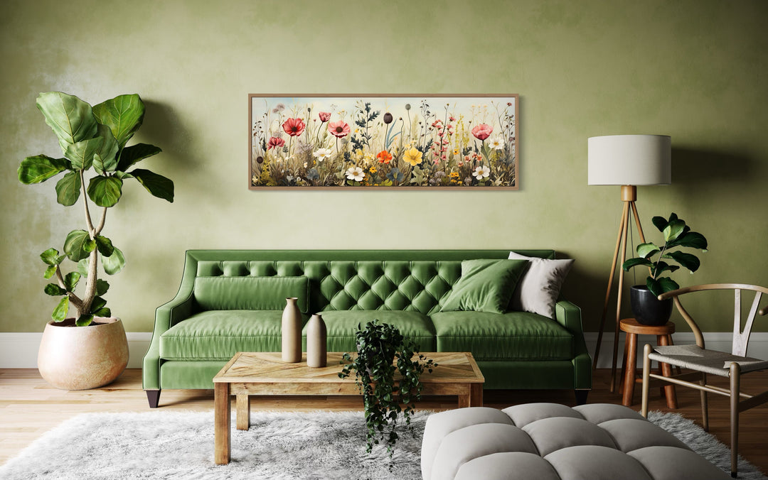 Vintage wildflowers field horizontal framed canvas wall art above a green sofa in a living room.