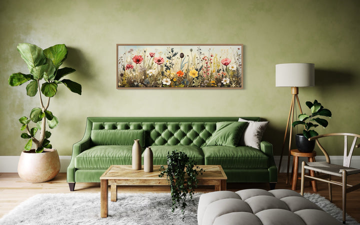 Vintage wildflowers field horizontal framed canvas wall art above a green sofa in a living room.