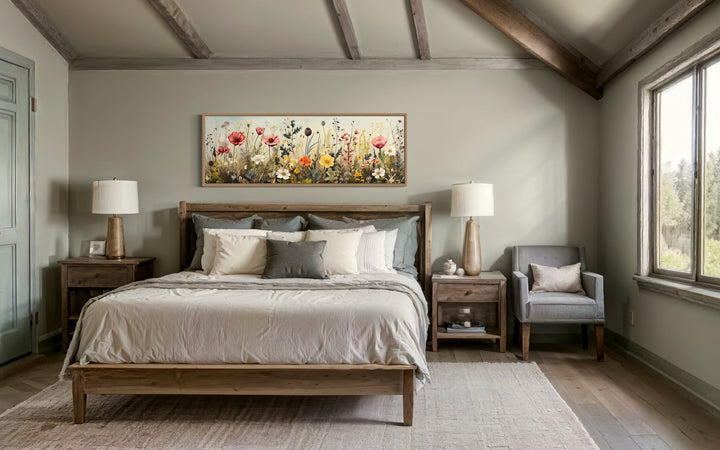 Vintage wildflowers field long horizontal framed canvas wall art hanging above a wooden bed frame.