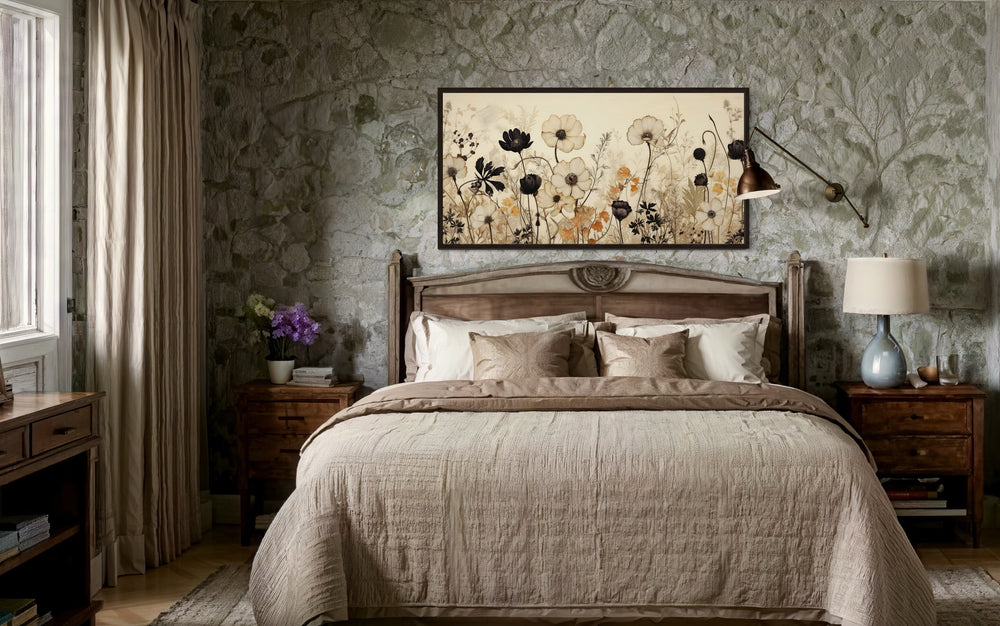 Vintage wildflower canvas wall art in neutral tones hanging above a bed in a rustic bedroom.