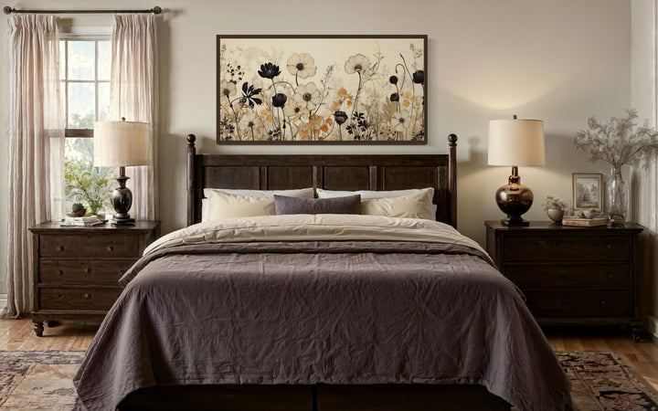 Vintage wildflower canvas wall art with neutral floral silhouettes above a dark wood bed frame.