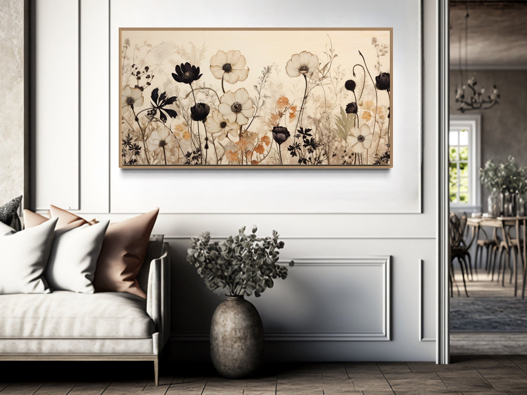 Vintage wildflower canvas wall art in neutral tones hanging above a sofa in a farmhouse living room.
