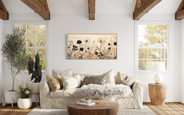 Vintage wildflower canvas wall art in a neutral farmhouse living room above a beige sofa.