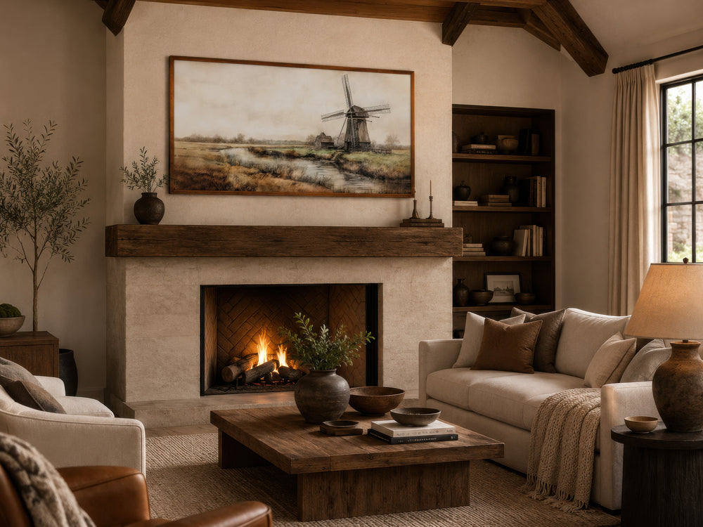 Vintage windmill canvas print in a wooden frame hanging above a rustic fireplace in a living room.